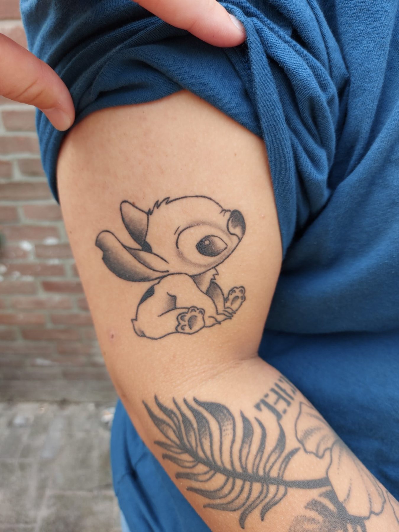 Stitch op de bovenarm, met een veer eronder