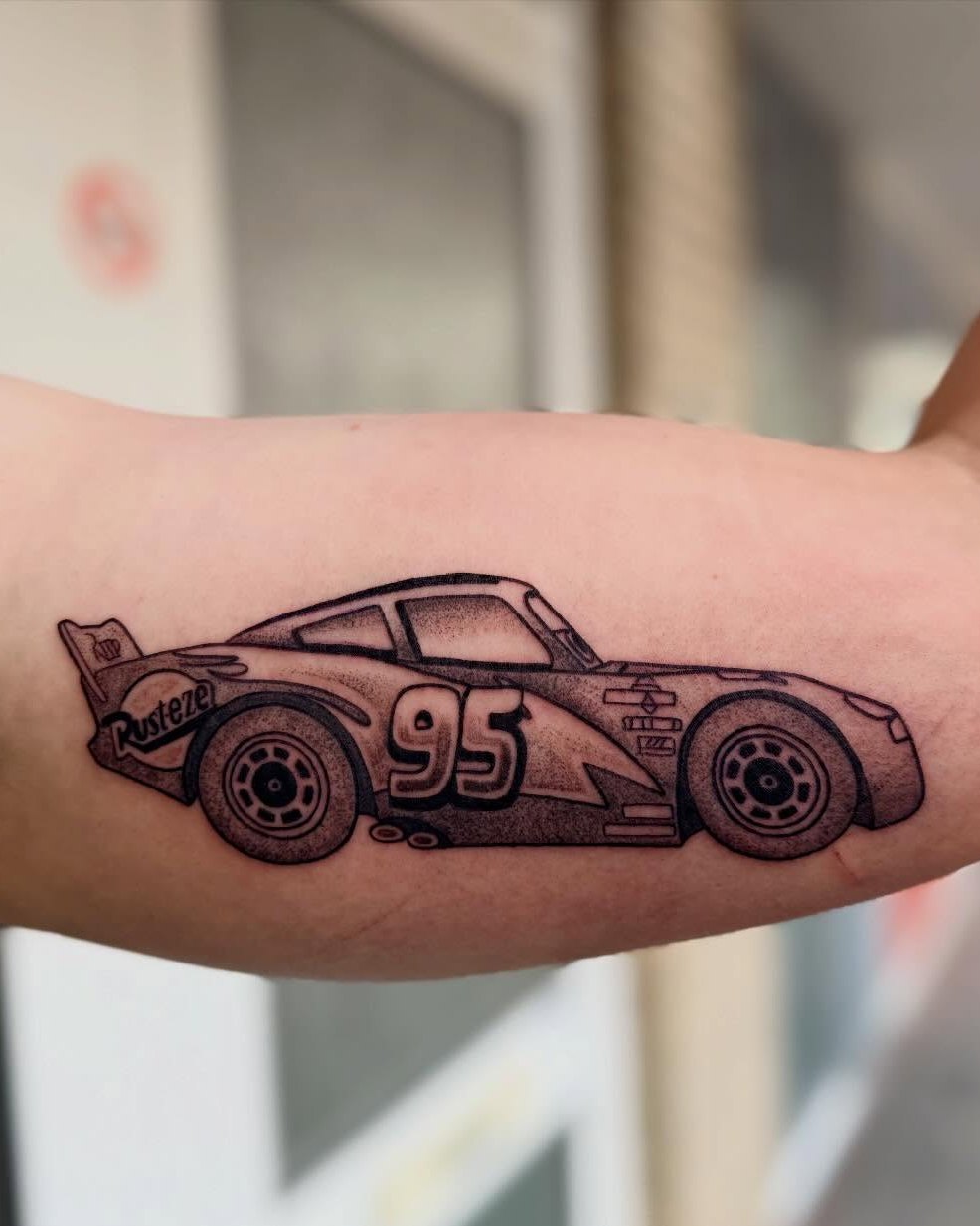 Lightning McQueen met nummer 95 op een bovenarm